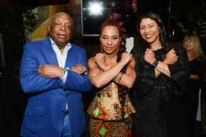 Three smiling attendees posing with crossed arms