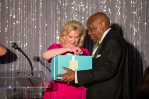 Woman handing turquoise gift box to man